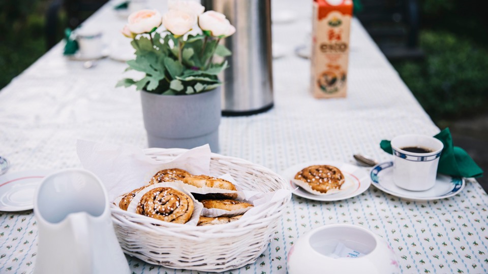 Ett fikabord med kaffe, bullar och mjölk.